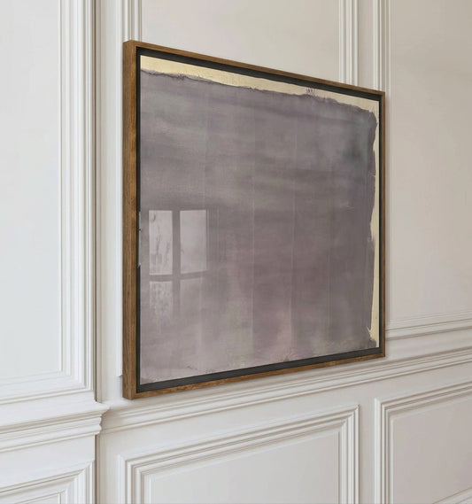 Abstract makelberge painting in a wooden frame on a wall with decorative paneling