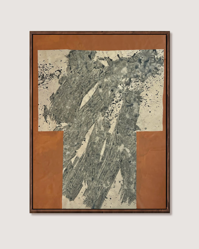 A framed abstract art by Nicolas Makelberge featuring textured gray and black brushstrokes on a cream background, surrounded by a warm terracotta border and a dark brown frame, shown against a light gray wall.