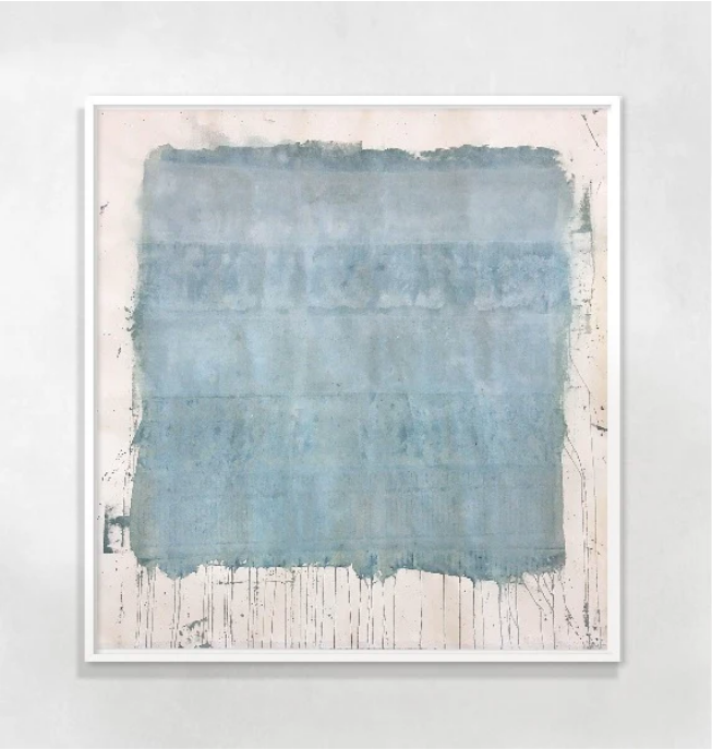 A framed abstract artwork featuring various shades of blue and gray, with white spaces creating a contrast.