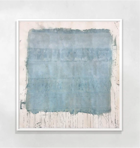A framed abstract artwork featuring various shades of blue and gray, with white spaces creating a contrast.