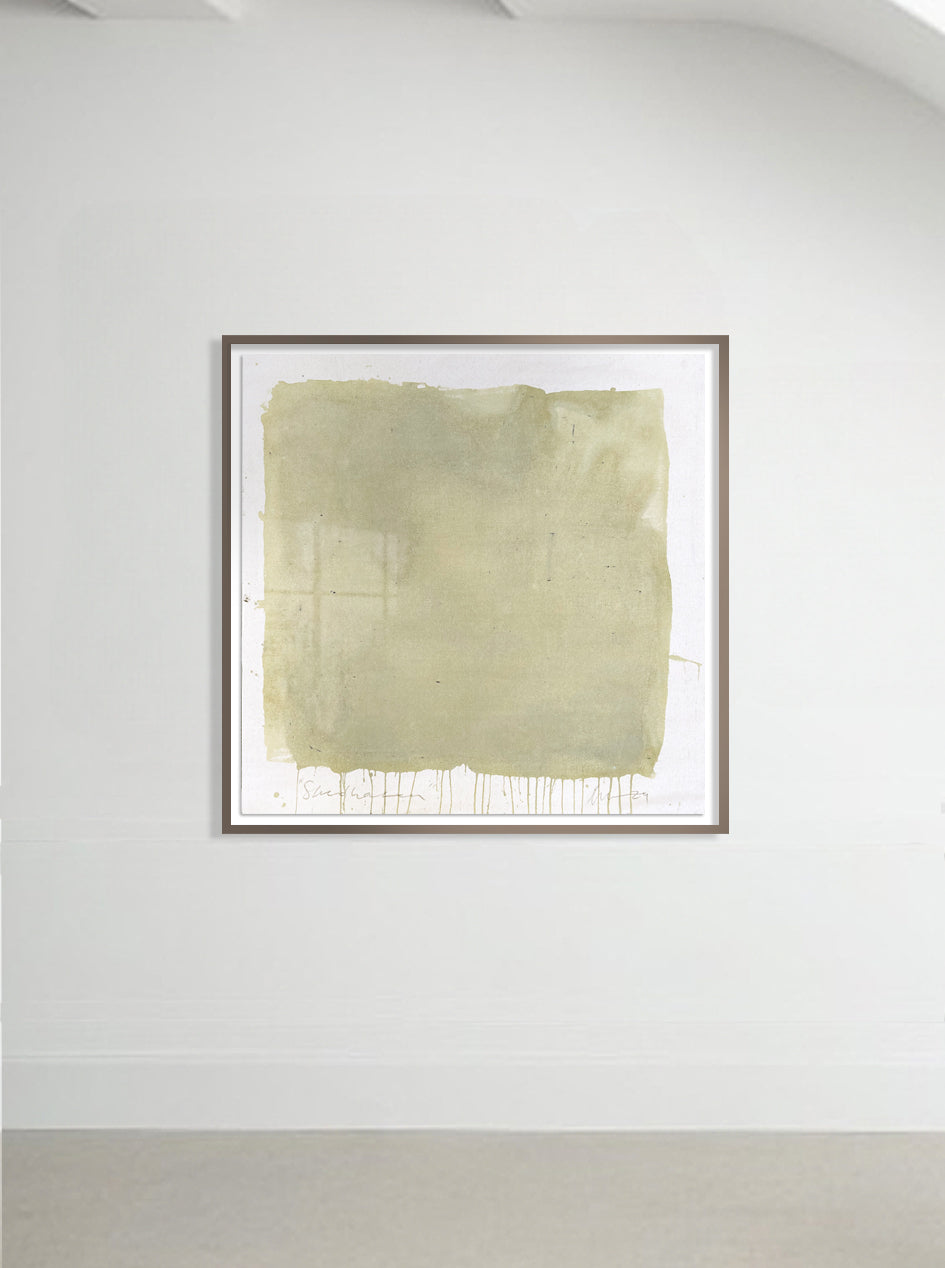 A framed abstract artwork in green and yellow tones, presented on a wall.