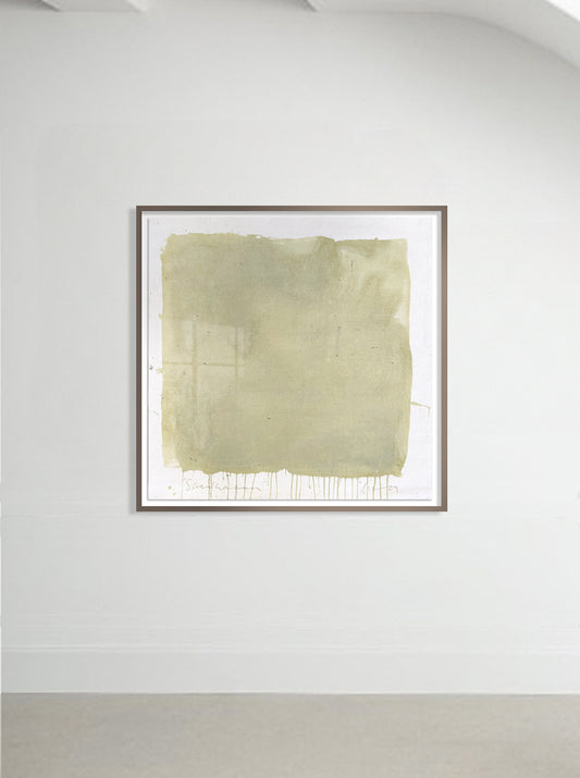 A framed abstract artwork in green and yellow tones, presented on a wall.