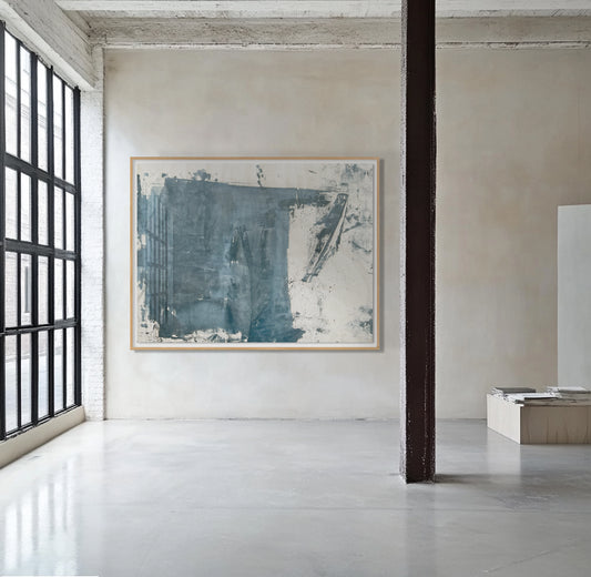 A abstract artwork mounted on a wall in a room with high ceilings and large windows, featuring shades of blue and beige.