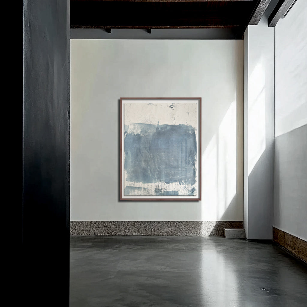 A framed abstract artwork hanging on a wall in a room with natural lighting.