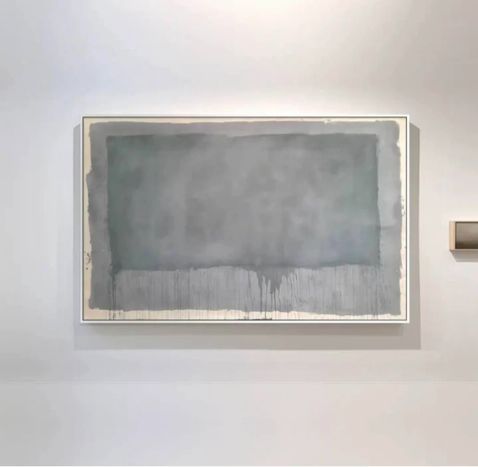 A framed artwork featuring shades of gray and teal, mounted under glass.