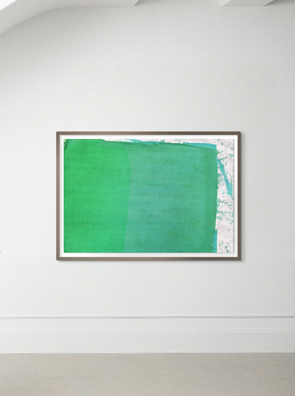 A framed abstract painting with two-tone green colors displayed on a wall.