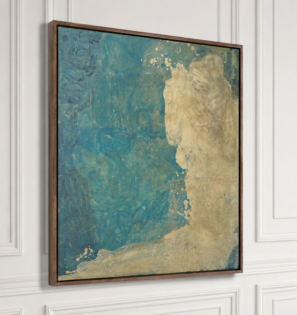 An abstract framed wall art print featuring textured blue and beige tones, hung on a white paneled wall.