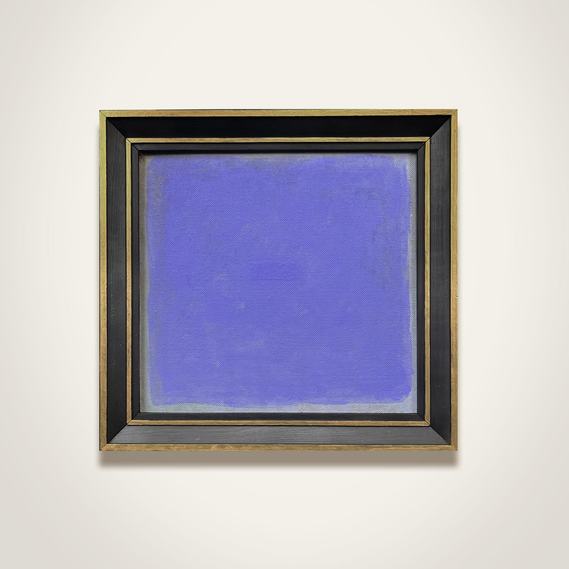 Framed abstract painting with a blue background on a white wall