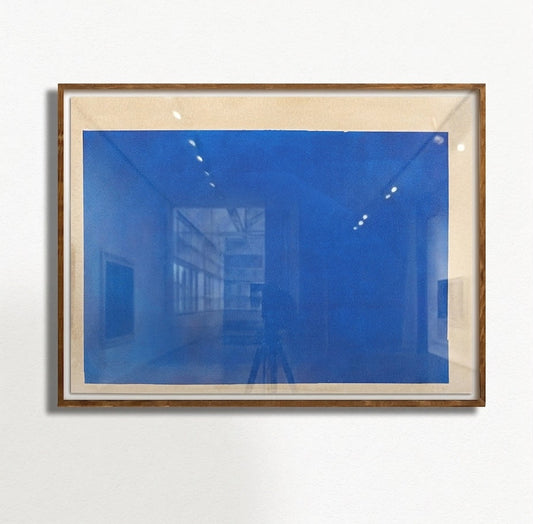 Framed makelberge artwork with a blue abstract design on a white wall