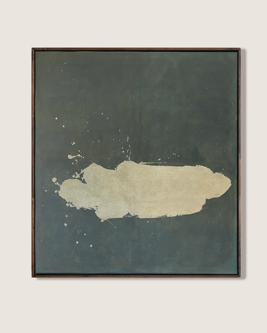 A framed abstract painting featuring a textured dark slate-green background with a central cream-colored brushstroke, displayed on a light beige wall.