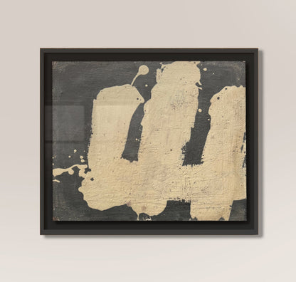 Framed abstract art piece by makelberge with black and gold colors on a beige wall.