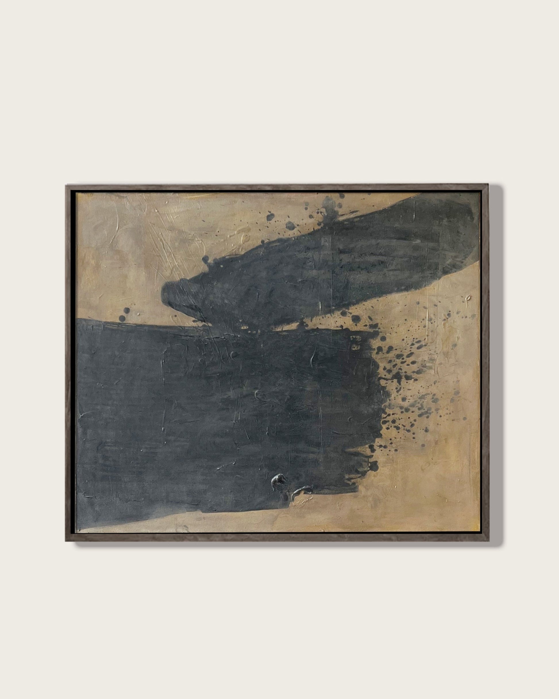 Abstract art piece with black and gold colors on a white wall