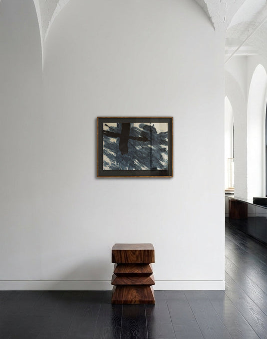 Modern interior with a stack of wooden stools against a white wall with a mirror.