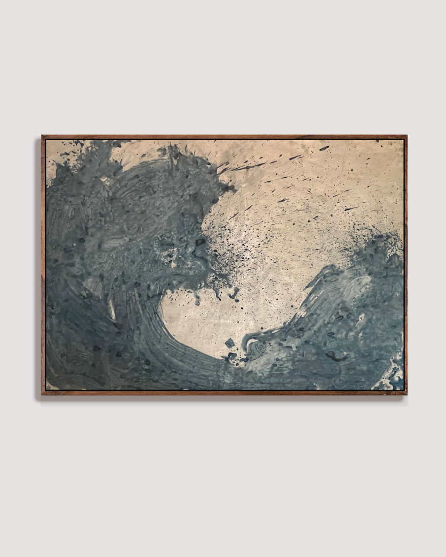 An abstract framed painting featuring a wave-like composition with textured dark blue-gray and beige paint, by Nicolas Makelberge displayed against a light gray wall.