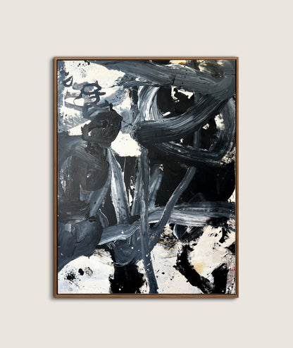 Abstract art print in a wooden frame on a light gray wall