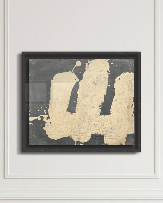 Framed abstract art piece by Makelberge with gold and black design on a white wall.