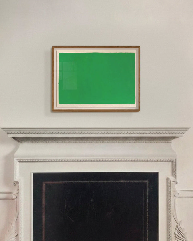 Green screen framed picture above a fireplace in a room with white walls.