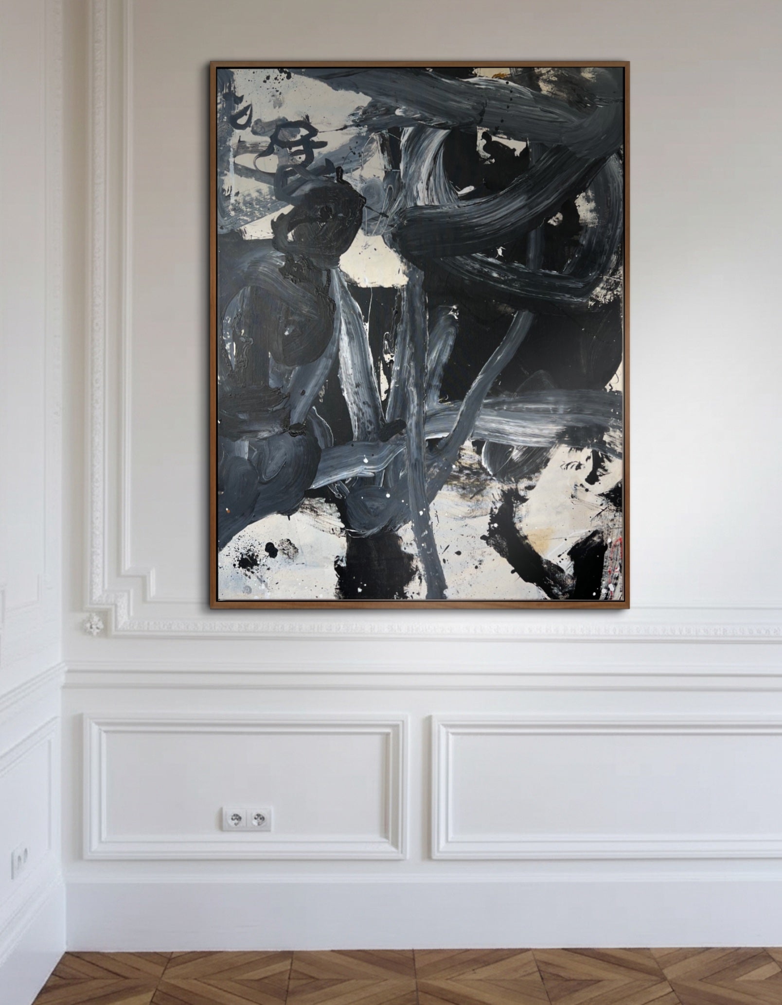 Abstract painting in a wooden frame on a white wall with decorative molding.