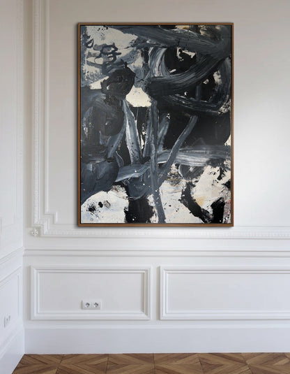 Abstract painting in a wooden frame on a white wall with decorative molding.