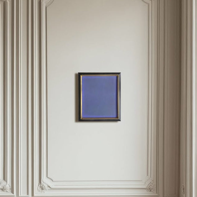 Decorative wall paneling with a framed blue artwork in a room with large windows.