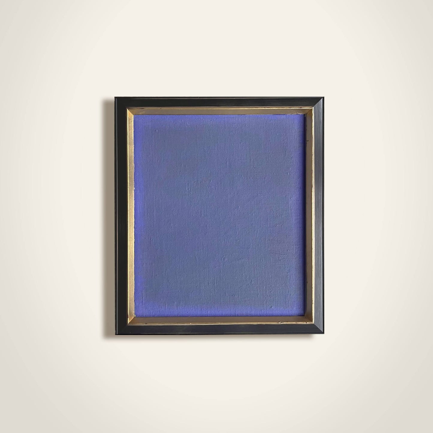 Framed abstract painting with a blue textured canvas on a white wall